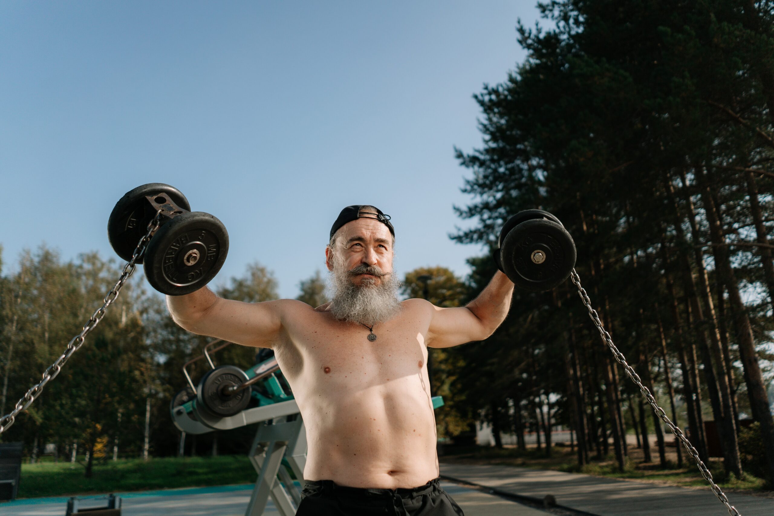 older man lifting dumbbells with chains