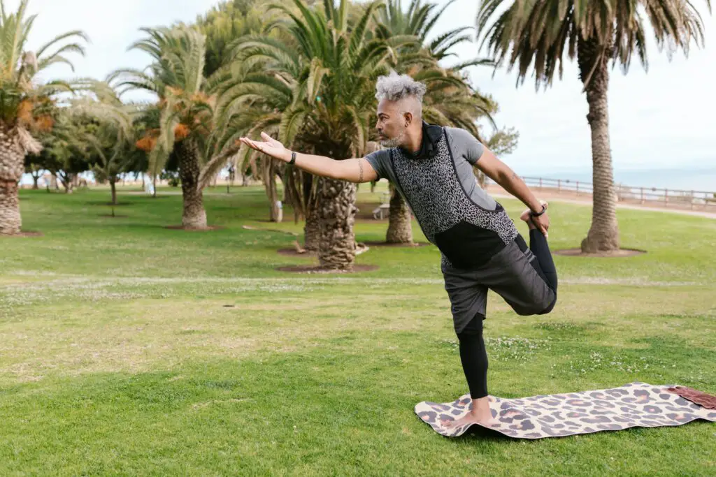 senior balancing at beach on one leg