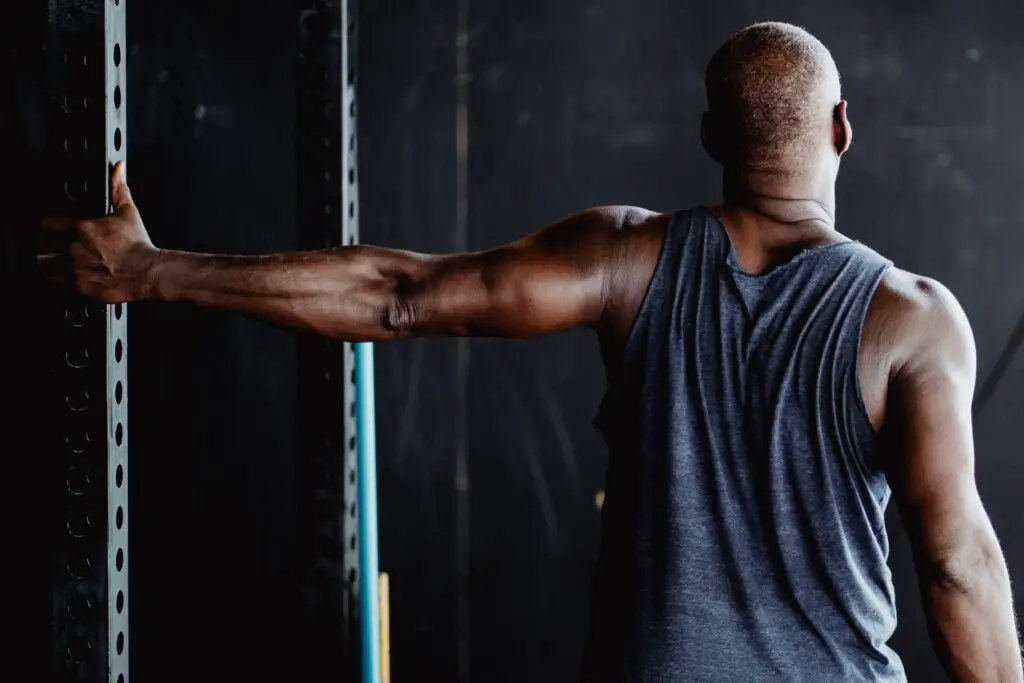 man performing pec stretch on wall single arm