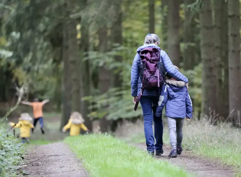 mother and kids walking in the forest